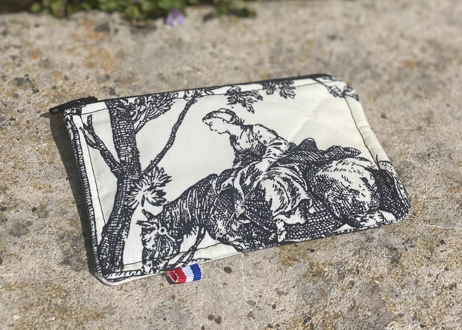 Détail du tissu d’ameublement et couture artisanale du porte-monnaie
