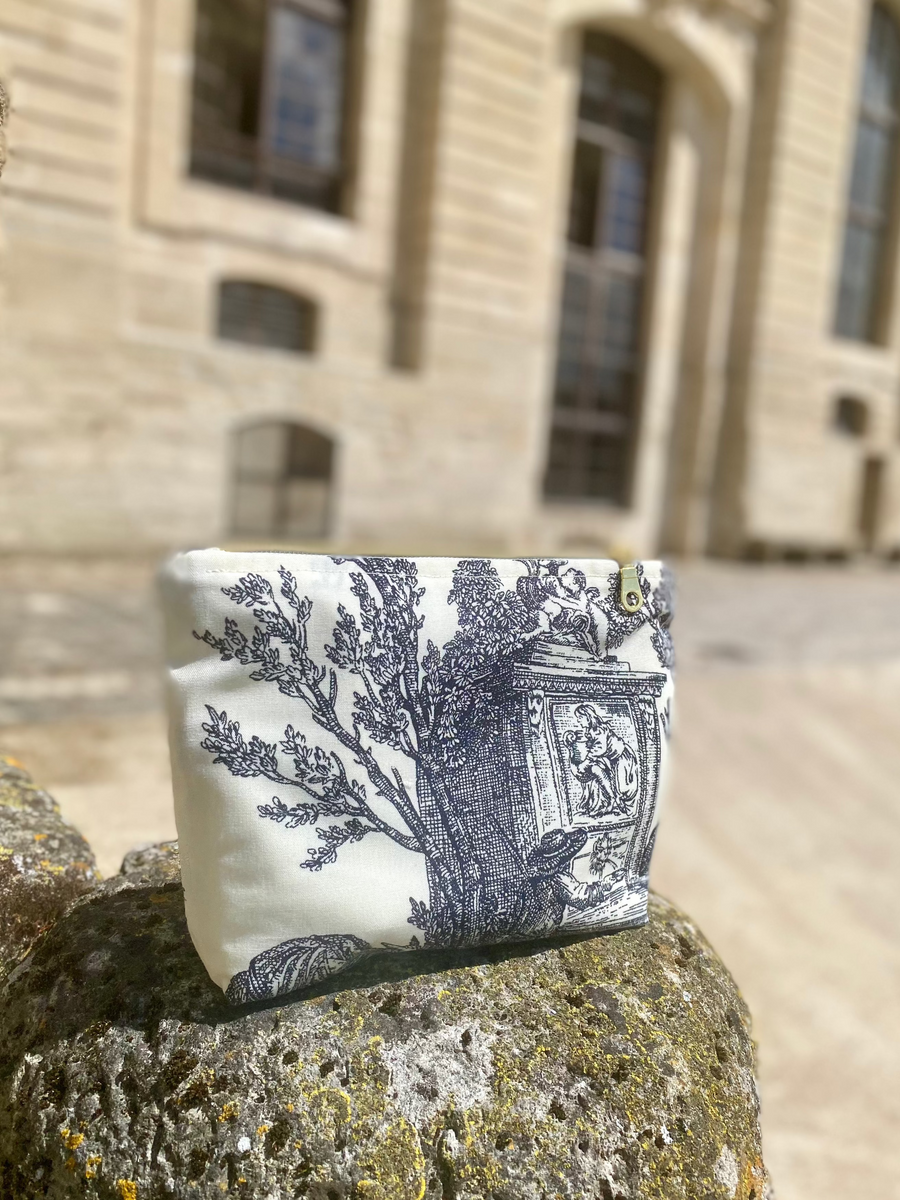 Vanity pouch in toile de Jouy in front of a château façade