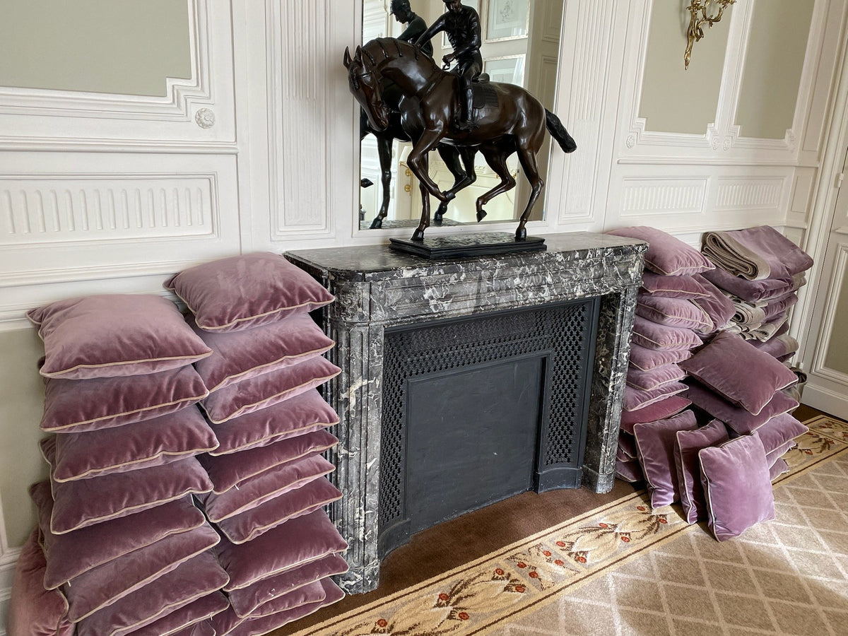Coussins et tentures déposés au pied d'une cheminée lors de la rénovation d'un hôtel