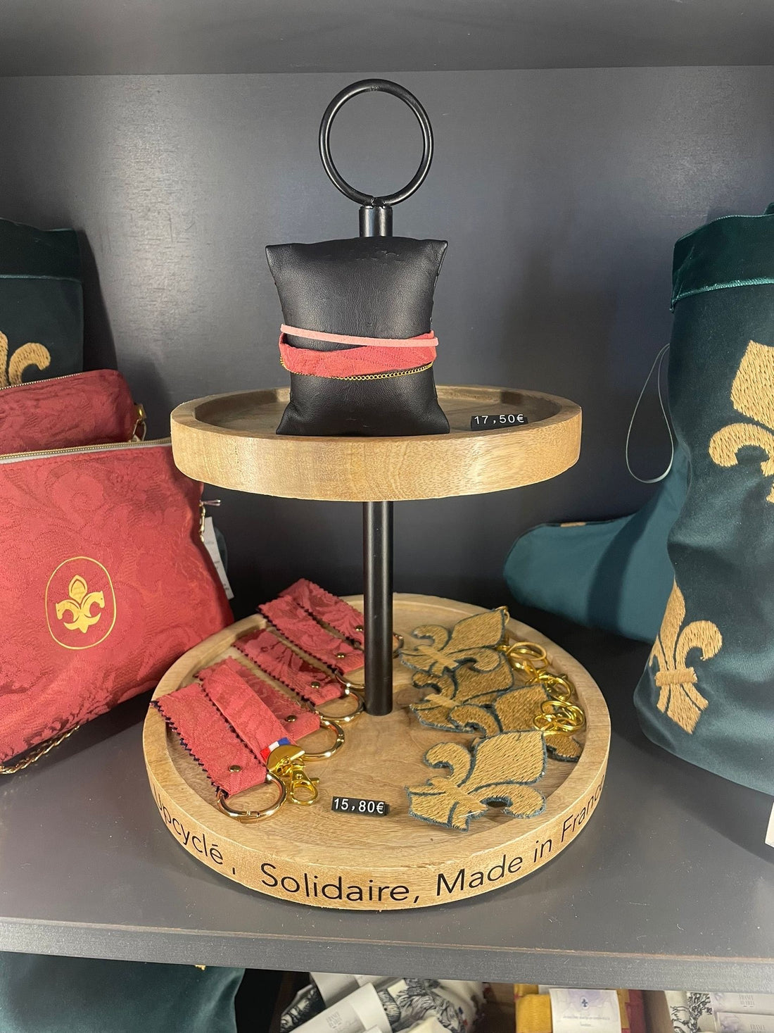 Pouches in red damask and green velvet embroidered with fleurs-de-lis, displayed in a château shop