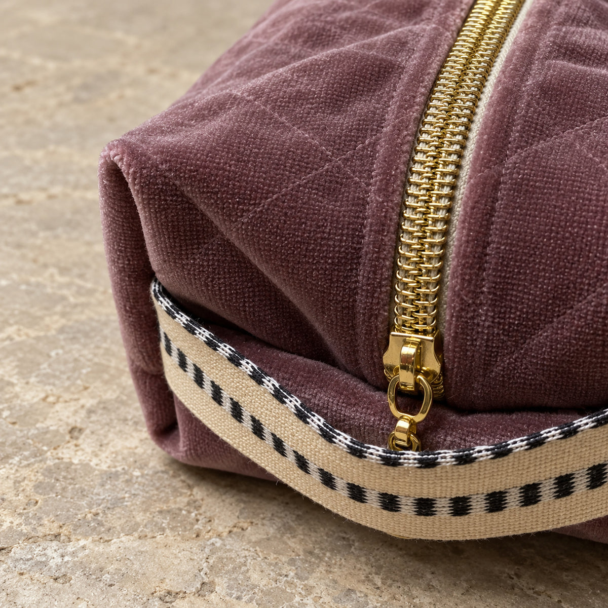 Détail du velours violet, de la fermeture et de la poignée rayée